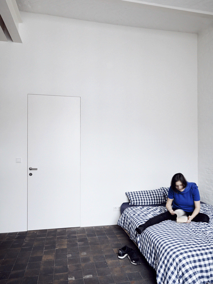 Industrial Schlafzimmer mit weißer Wandfarbe, Backsteinboden und rotem Boden in Berlin