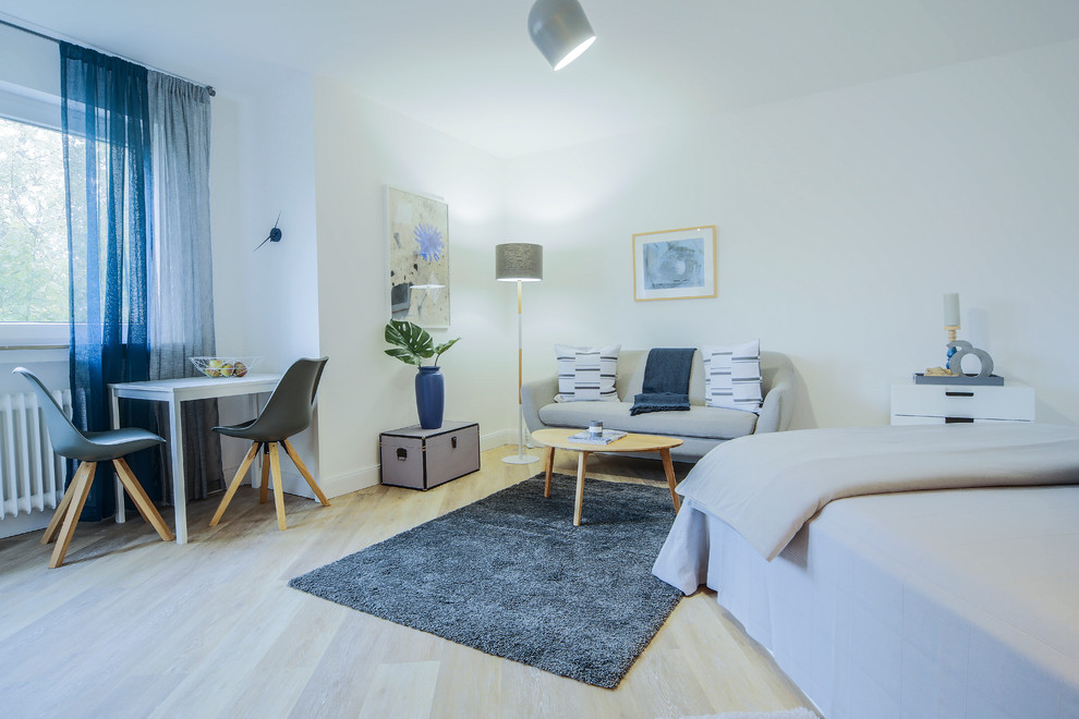 This is an example of a large scandi master bedroom in Dusseldorf with white walls, light hardwood flooring, no fireplace and beige floors.