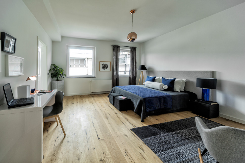 Großes Modernes Hauptschlafzimmer ohne Kamin mit weißer Wandfarbe, braunem Holzboden und braunem Boden in Düsseldorf