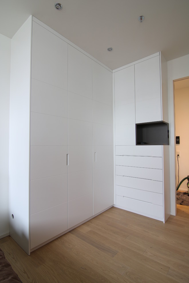 Mittelgroßes Modernes Hauptschlafzimmer mit weißer Wandfarbe und hellem Holzboden in München