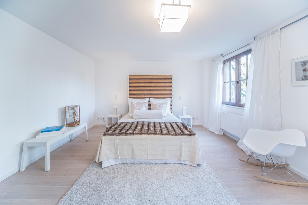 Exemple d'une chambre parentale tendance de taille moyenne avec un mur blanc, parquet clair et aucune cheminée.