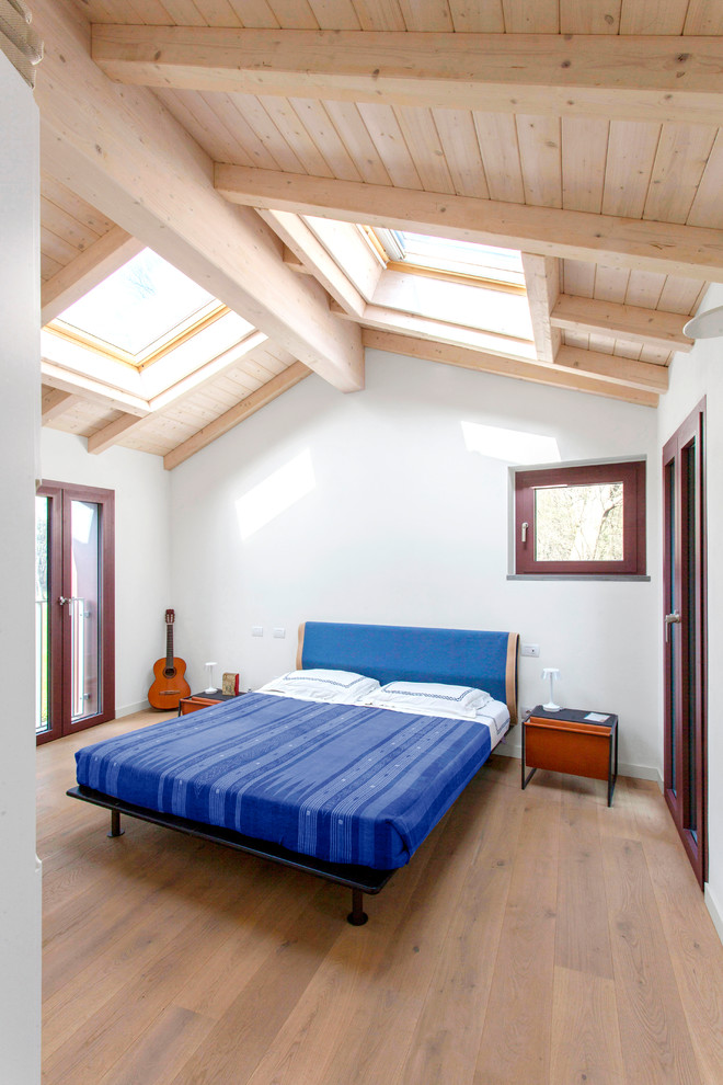 Ejemplo de dormitorio contemporáneo con paredes grises, suelo de madera en tonos medios y suelo marrón