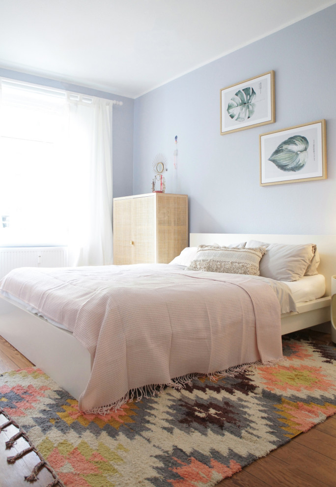 Foto di una camera matrimoniale minimal di medie dimensioni con pareti blu e pavimento in legno massello medio