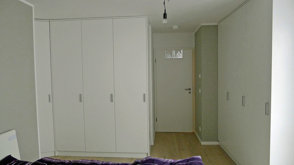 Mittelgroßes Modernes Hauptschlafzimmer ohne Kamin mit grauer Wandfarbe, hellem Holzboden und braunem Boden in München
