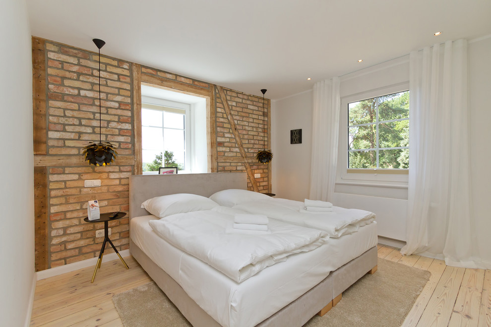 Diseño de dormitorio de estilo de casa de campo de tamaño medio con paredes blancas, suelo de madera clara y suelo marrón