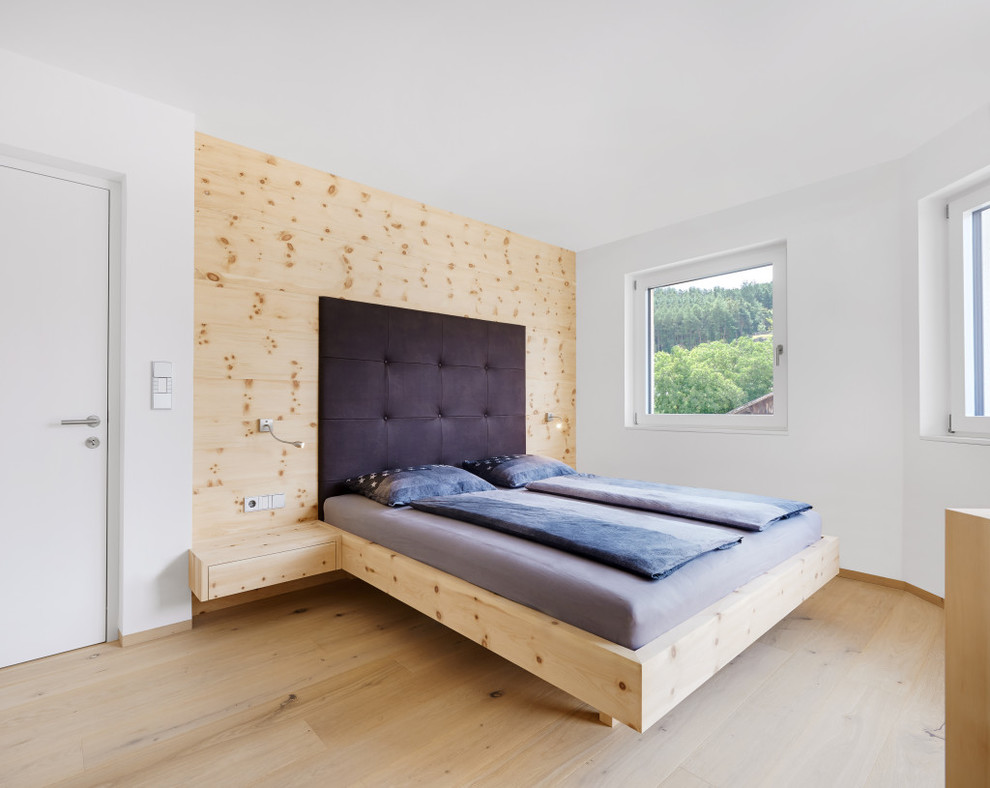 Imagen de dormitorio principal escandinavo grande con paredes blancas y suelo de madera clara