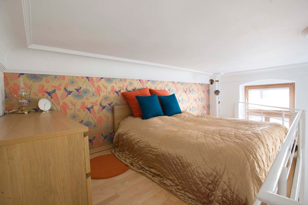 Kleines Stilmix Schlafzimmer ohne Kamin mit bunten Wänden und hellem Holzboden in Köln