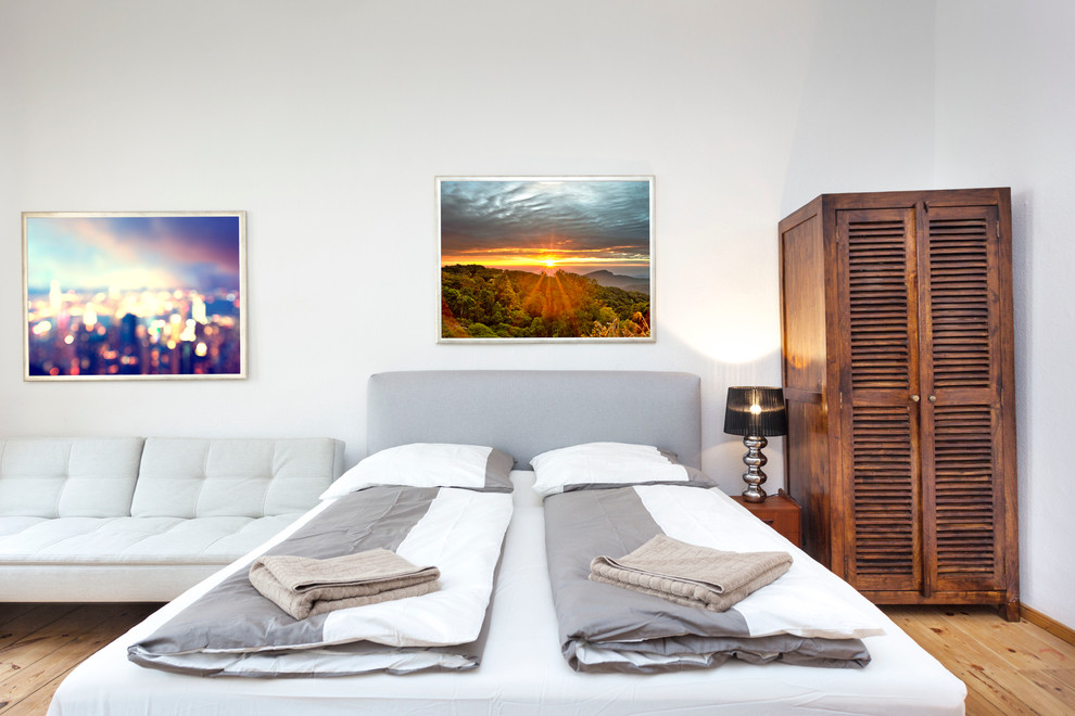 Mittelgroßes Retro Schlafzimmer mit weißer Wandfarbe und braunem Holzboden in Sonstige