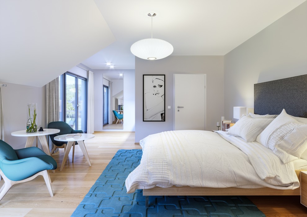 Modelo de dormitorio principal actual grande sin chimenea con paredes grises, suelo de madera clara y suelo beige