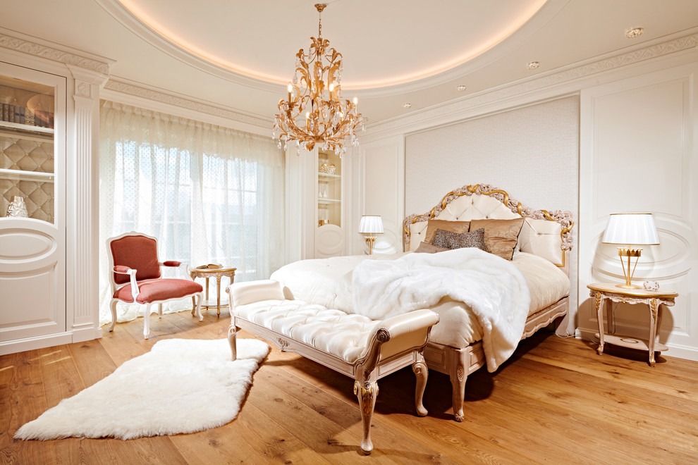 Ejemplo de dormitorio principal clásico de tamaño medio con paredes blancas, suelo de madera pintada, todas las chimeneas, marco de chimenea de piedra y suelo marrón