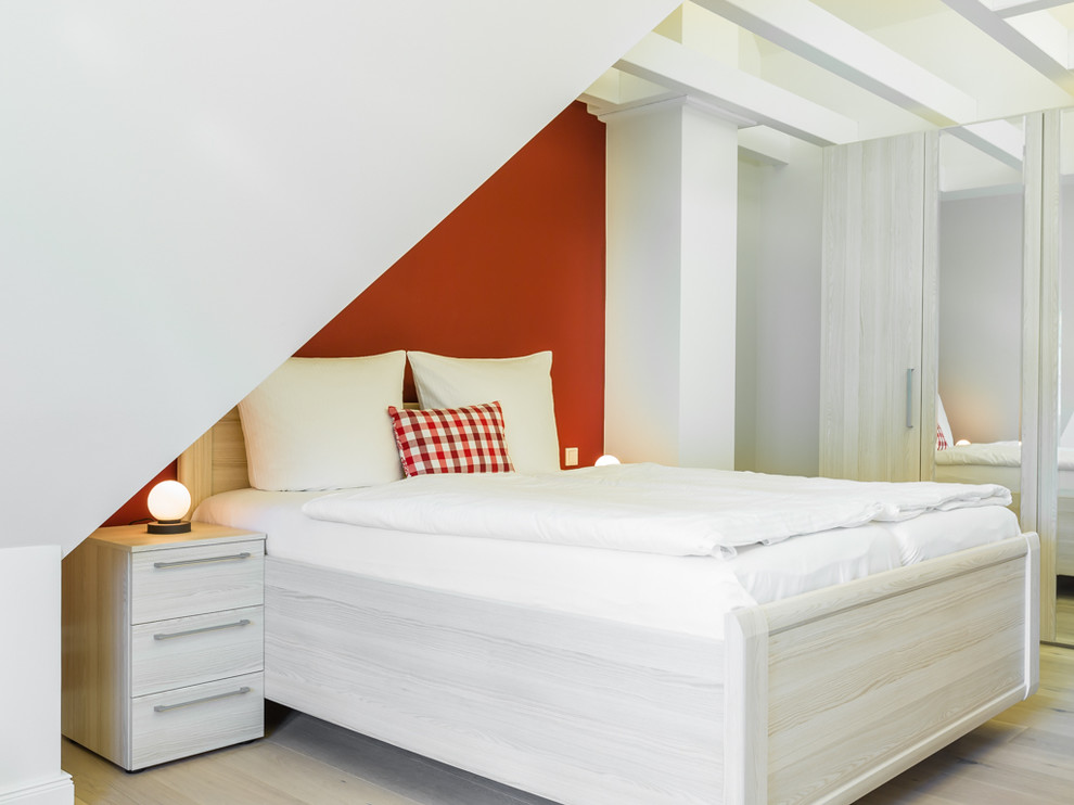 Foto de dormitorio principal campestre pequeño sin chimenea con paredes rojas y suelo de madera clara