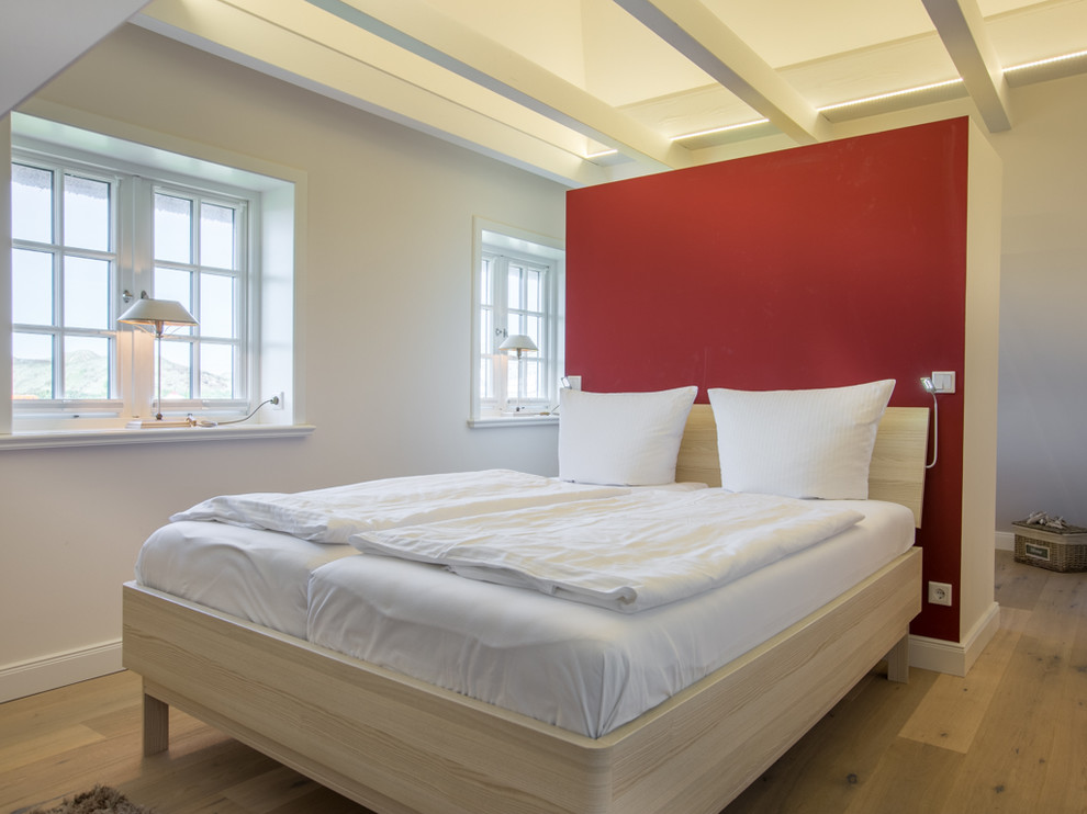 Exemple d'une chambre parentale nature de taille moyenne avec un mur rouge, un sol en bois brun et aucune cheminée.