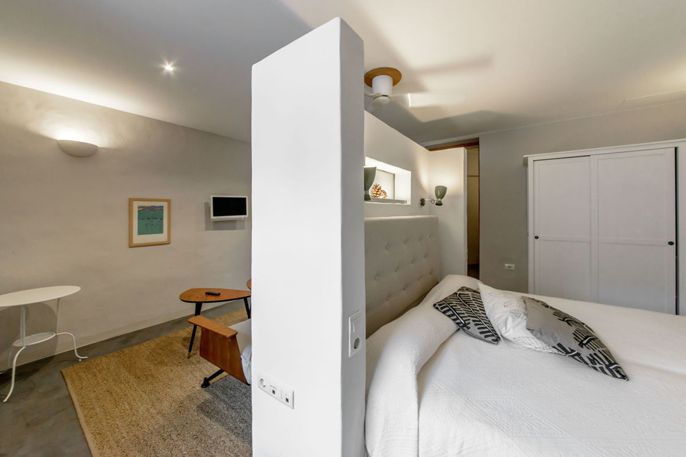 Foto de dormitorio principal contemporáneo pequeño sin chimenea con paredes grises y suelo de cemento