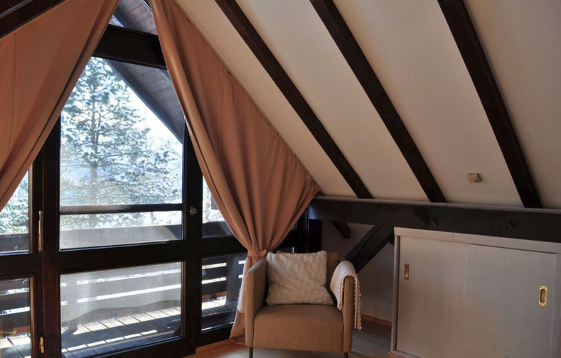 Modelo de dormitorio principal rústico de tamaño medio sin chimenea con paredes rojas, suelo de madera en tonos medios y suelo beige