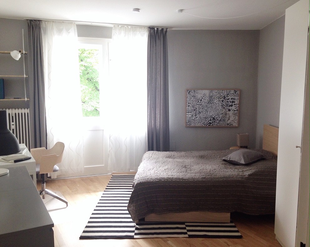 Bild på ett litet minimalistiskt huvudsovrum, med grå väggar och mellanmörkt trägolv