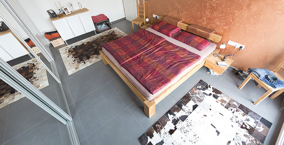 Mid-sized island style master ceramic tile and gray floor bedroom photo in Stuttgart with orange walls