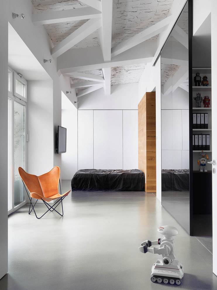 Großes Modernes Schlafzimmer im Dachboden ohne Kamin mit weißer Wandfarbe und Betonboden in Berlin