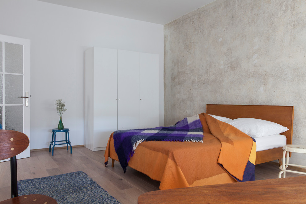 Modelo de dormitorio principal actual de tamaño medio con paredes beige, suelo de madera en tonos medios y suelo marrón