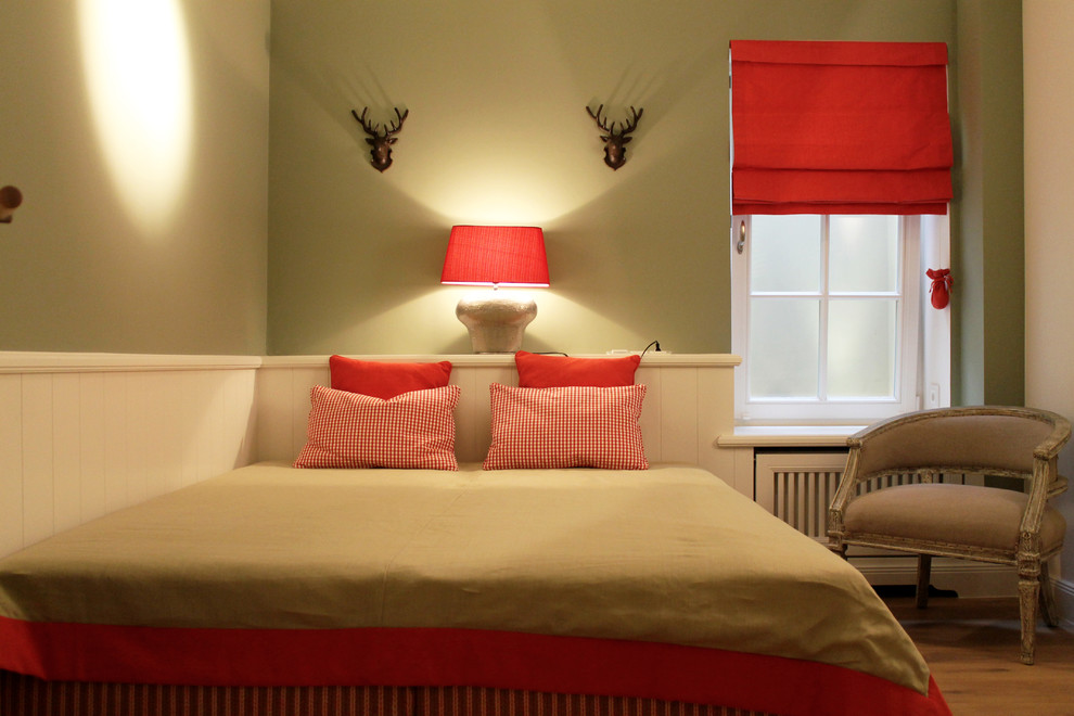 На фото: маленькая гостевая спальня (комната для гостей) в стиле кантри с зелеными стенами и паркетным полом среднего тона без камина для на участке и в саду