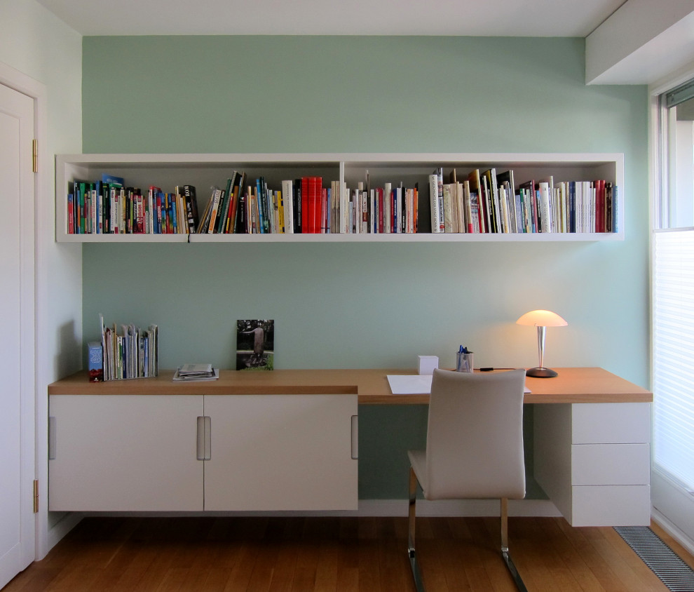 Inspiration pour une petite chambre d'amis design avec un mur vert, un sol en bois brun et un sol marron.