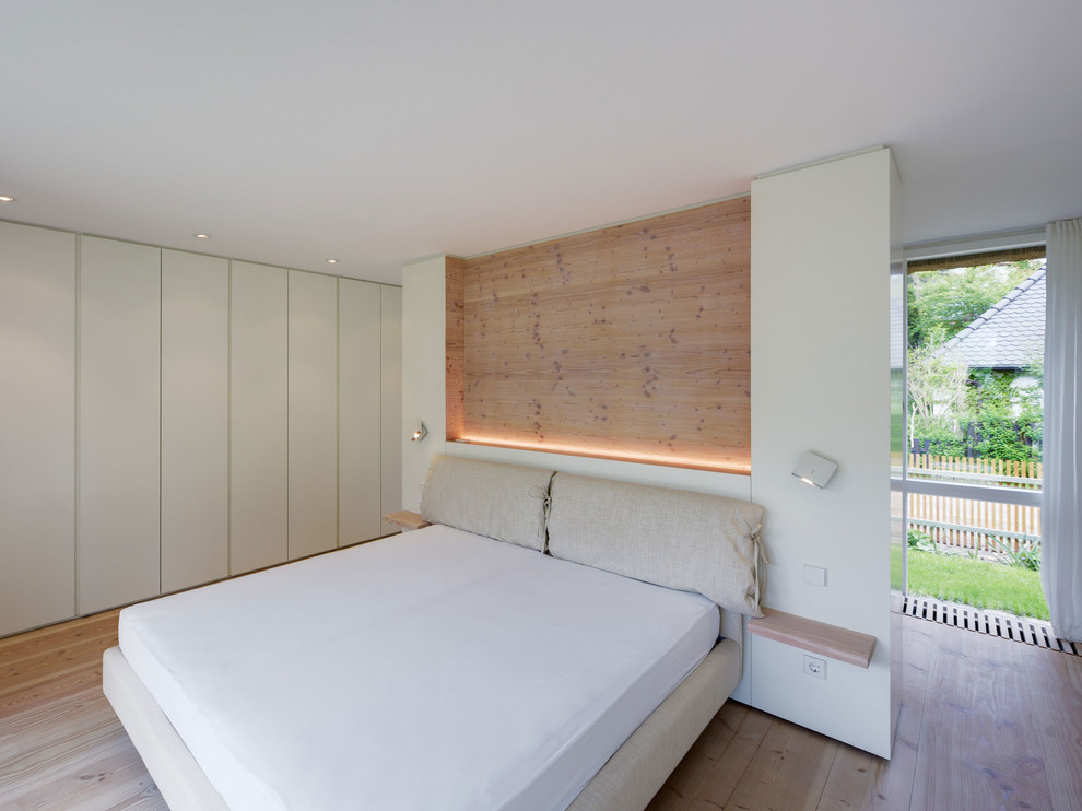 Mittelgroßes Modernes Hauptschlafzimmer ohne Kamin mit weißer Wandfarbe und hellem Holzboden in Berlin