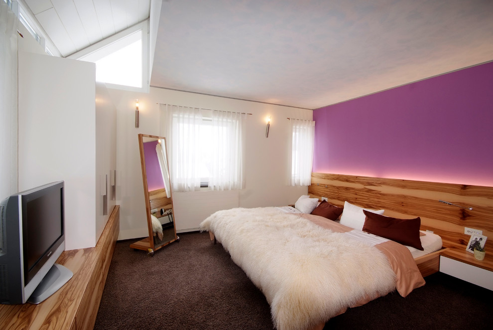 Immagine di una camera matrimoniale contemporanea di medie dimensioni con pareti viola, moquette e pavimento marrone