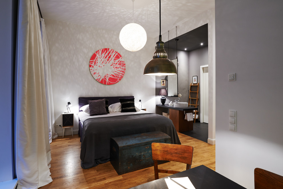 Mittelgroßes Modernes Hauptschlafzimmer ohne Kamin mit grauer Wandfarbe und braunem Holzboden in Berlin