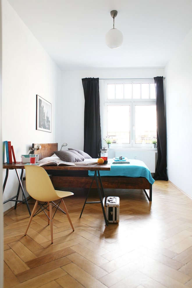 Réalisation d'une chambre d'amis nordique de taille moyenne avec un mur blanc et un sol en bois brun.
