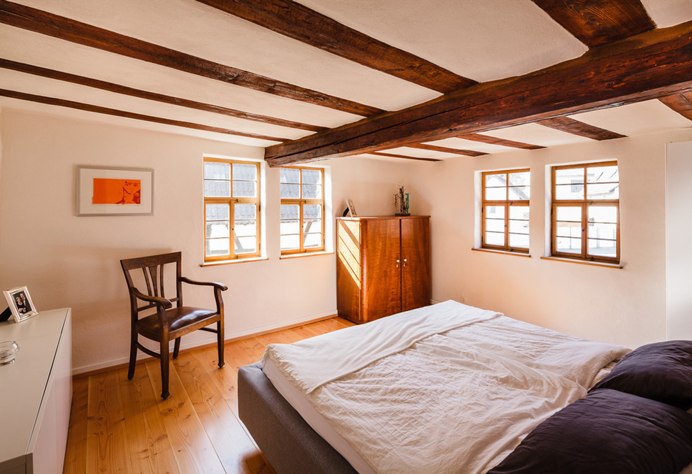 Uriges Schlafzimmer mit weißer Wandfarbe und hellem Holzboden in Frankfurt am Main