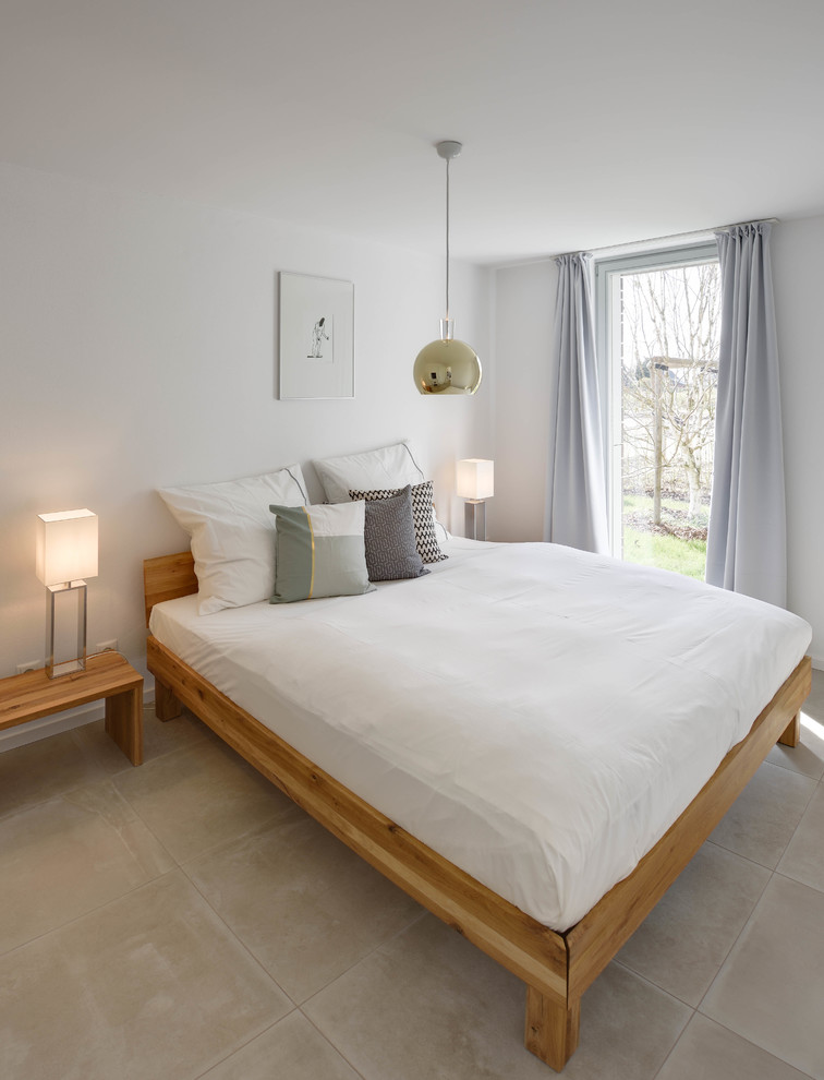 Diseño de dormitorio principal minimalista de tamaño medio sin chimenea con paredes blancas, suelo de baldosas de porcelana y suelo beige