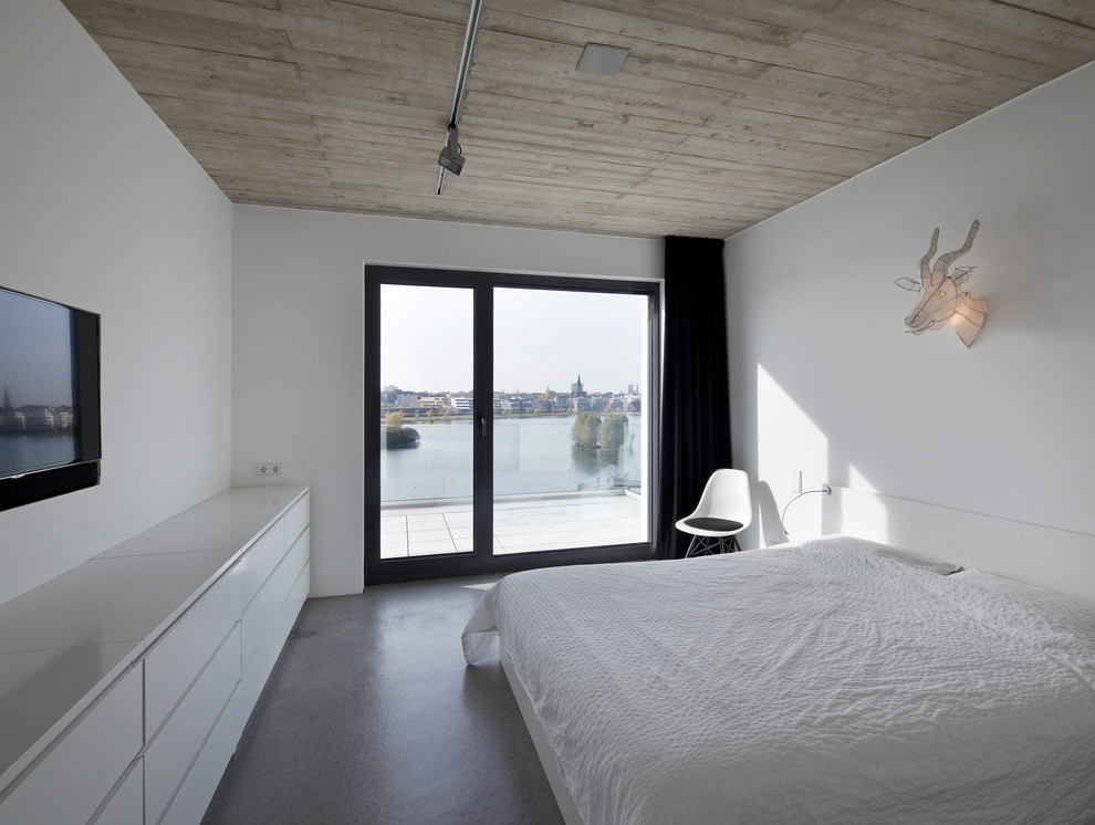 Mittelgroßes Modernes Gästezimmer ohne Kamin mit weißer Wandfarbe und Betonboden in Dortmund