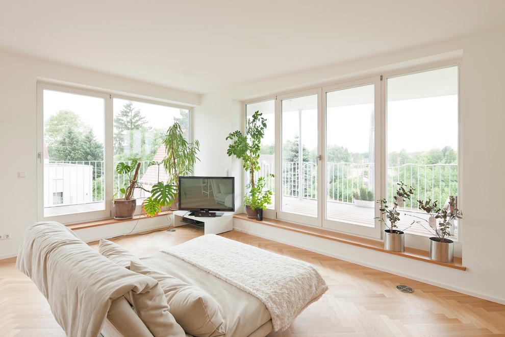 Источник вдохновения для домашнего уюта: большая спальня в скандинавском стиле с белыми стенами, паркетным полом среднего тона, коричневым полом и телевизором без камина