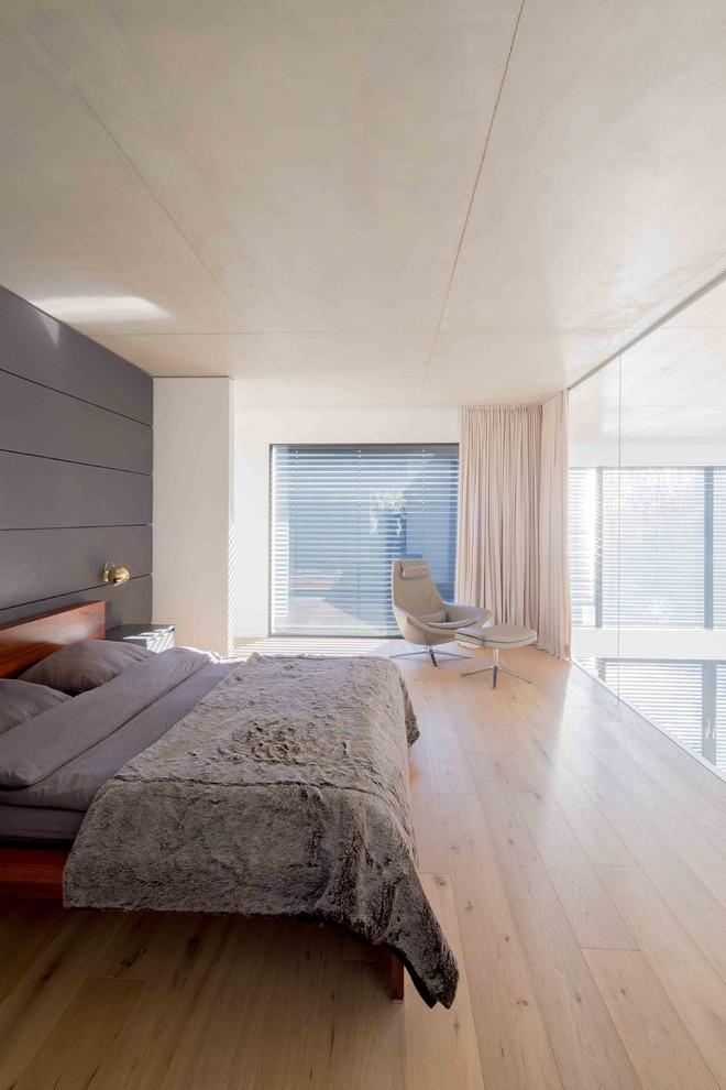 Großes Modernes Hauptschlafzimmer mit weißer Wandfarbe, braunem Holzboden und beigem Boden in Düsseldorf