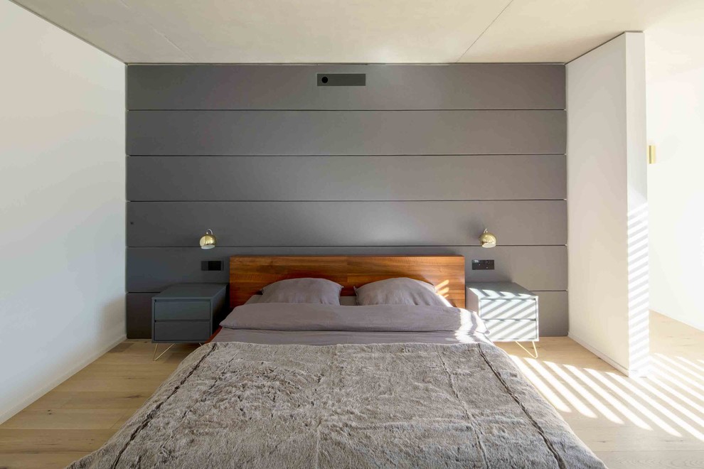 Idées déco pour une grande chambre parentale moderne avec un mur blanc, un sol en bois brun et un sol beige.