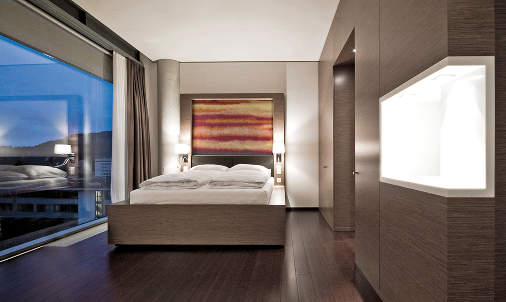 Foto de dormitorio contemporáneo grande sin chimenea con paredes marrones y suelo de madera oscura