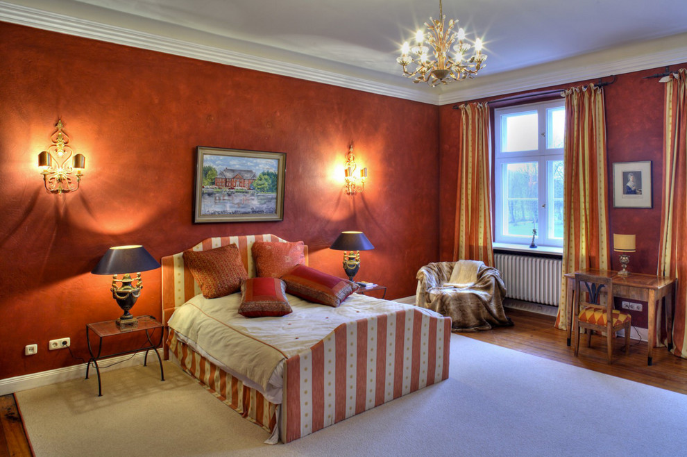 Immagine di una grande camera matrimoniale classica con pareti rosse e pavimento in legno massello medio