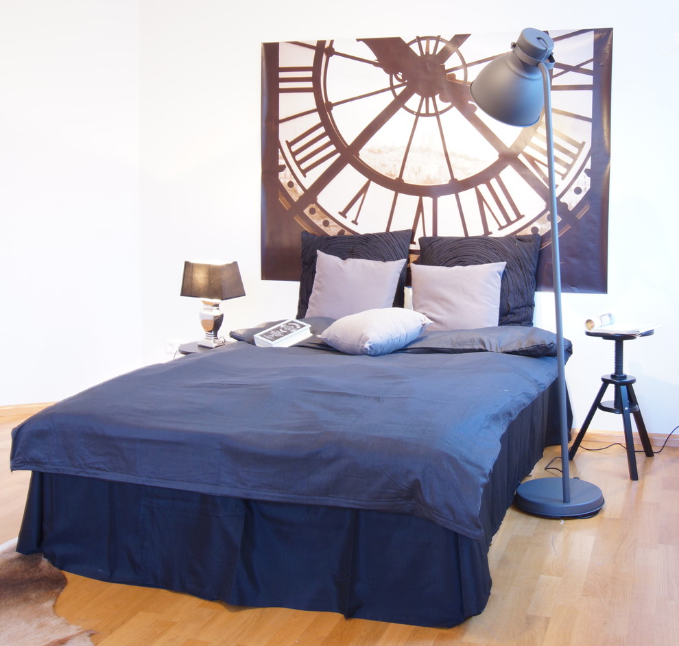 Modernes Schlafzimmer ohne Kamin mit weißer Wandfarbe und braunem Holzboden in Sonstige