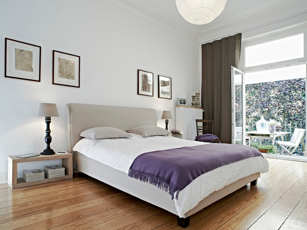 Großes Modernes Hauptschlafzimmer ohne Kamin mit weißer Wandfarbe und braunem Holzboden in Hamburg