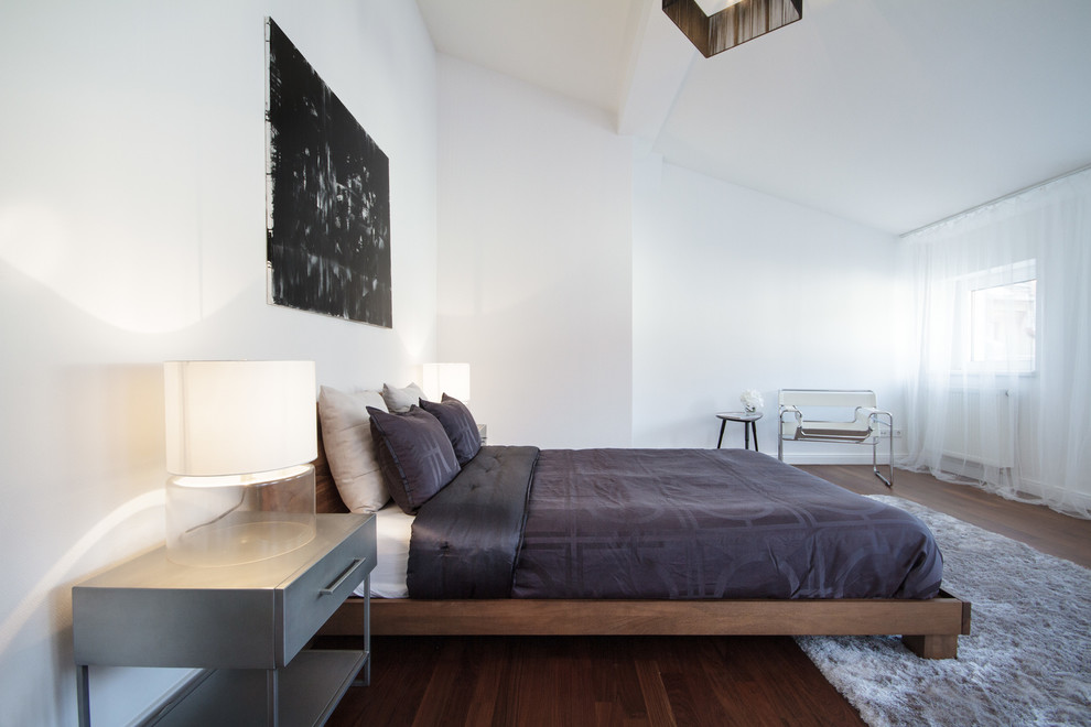 Mittelgroßes Modernes Hauptschlafzimmer mit weißer Wandfarbe, dunklem Holzboden und braunem Boden in Berlin