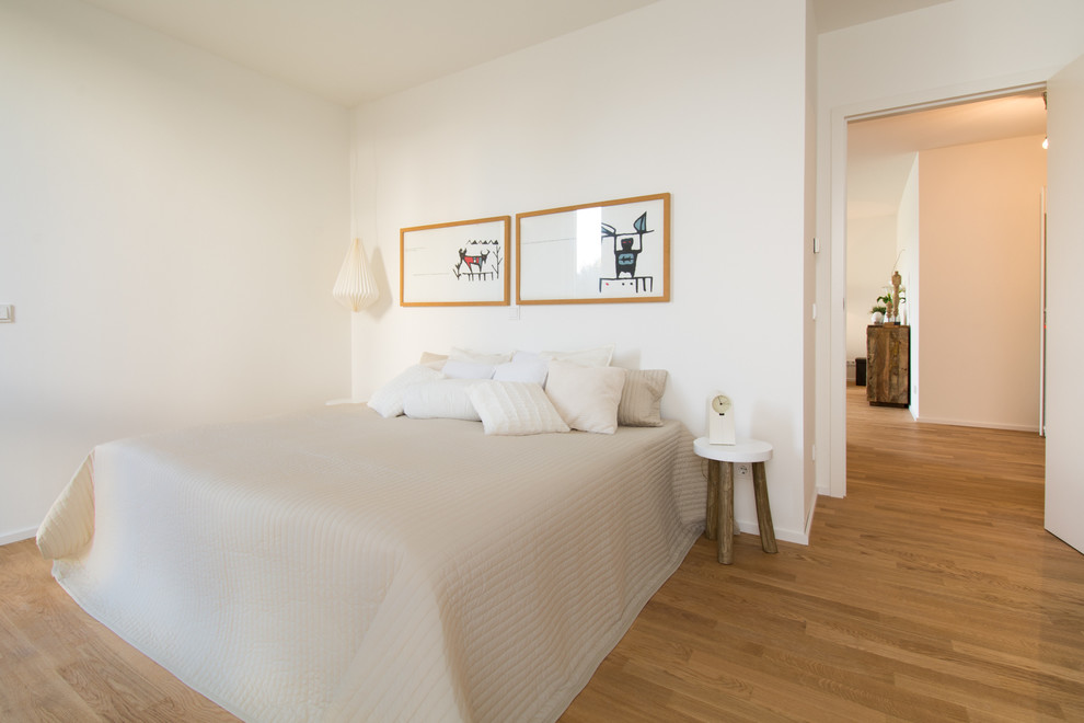 Mittelgroßes Skandinavisches Hauptschlafzimmer ohne Kamin mit weißer Wandfarbe und braunem Holzboden in Essen