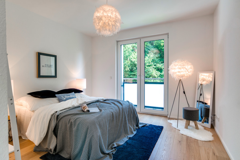 Modelo de habitación de invitados nórdica de tamaño medio sin chimenea con paredes blancas, suelo de madera clara y suelo beige