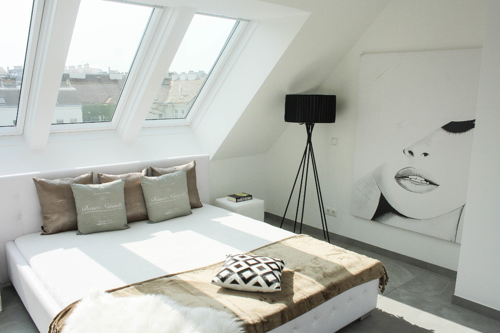 Modelo de dormitorio principal contemporáneo grande sin chimenea con paredes blancas, suelo de pizarra y suelo gris