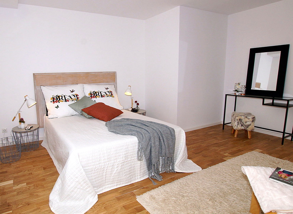 Cette photo montre une petite chambre scandinave avec un mur blanc et un sol en bois brun.