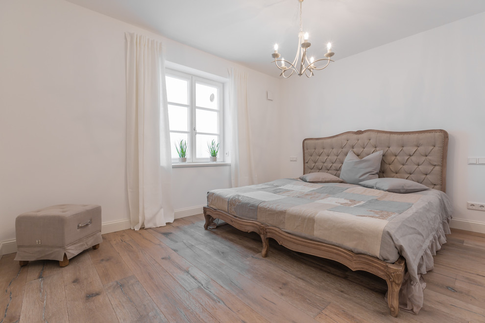 Großes Skandinavisches Hauptschlafzimmer ohne Kamin mit weißer Wandfarbe und braunem Holzboden in Sonstige
