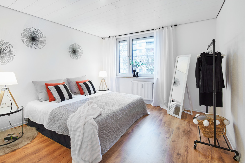 Modernes Schlafzimmer mit weißer Wandfarbe, braunem Holzboden und braunem Boden in Köln