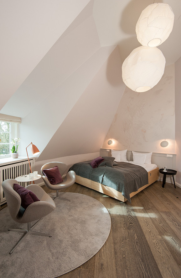 Großes Modernes Schlafzimmer ohne Kamin mit weißer Wandfarbe und dunklem Holzboden in Sonstige