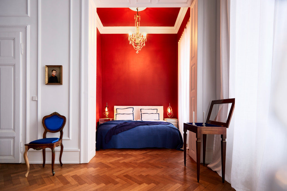 На фото: гостевая спальня (комната для гостей), среднего размера в классическом стиле с красными стенами, темным паркетным полом и коричневым полом без камина