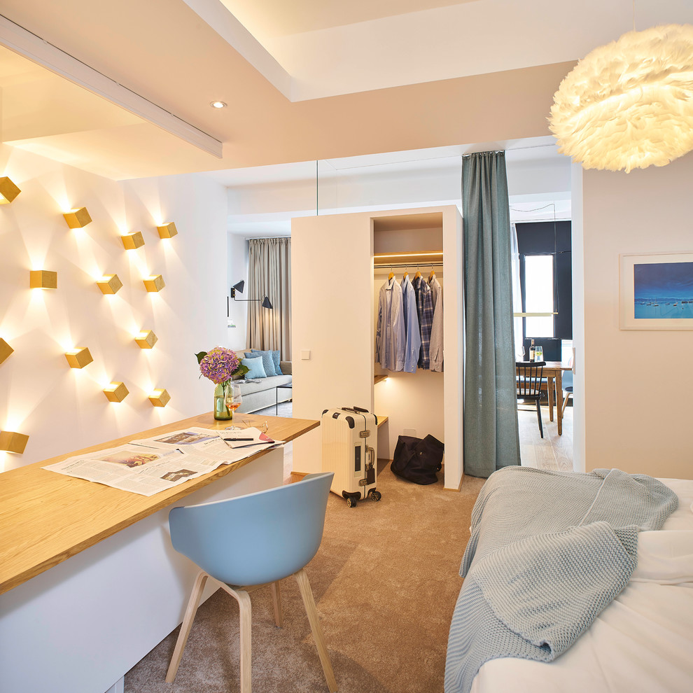 Geräumiges Modernes Schlafzimmer im Loft-Style mit weißer Wandfarbe, braunem Holzboden und beigem Boden in München