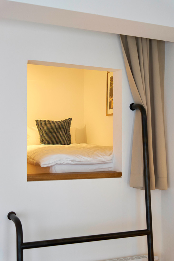 Ispirazione per una piccola camera degli ospiti contemporanea con pareti bianche, pavimento in legno massello medio e pavimento beige