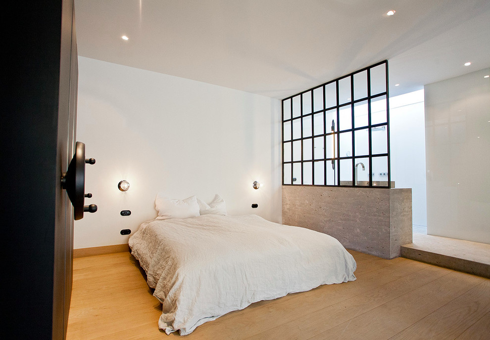 Photo of a large urban mezzanine bedroom in Munich with white walls, medium hardwood flooring and no fireplace.
